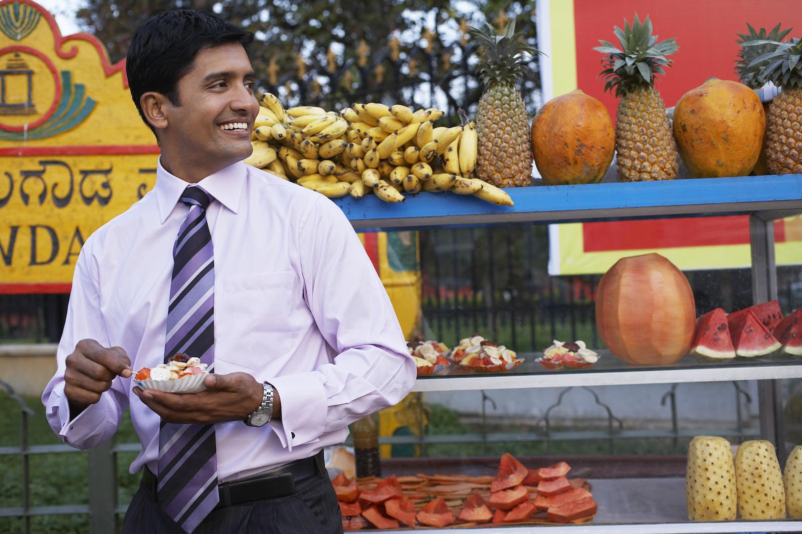 Businessman standing in front of fruit stall